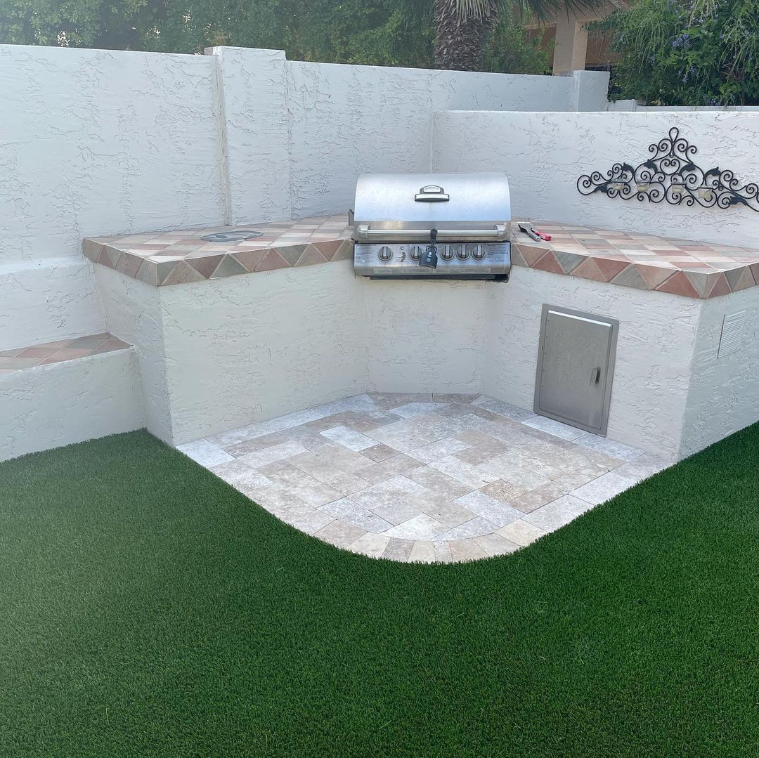 Outdoor grill surrounded by artificial turf