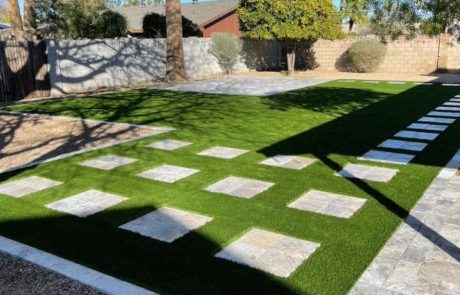 shady backyard with paver steps and artificial turf