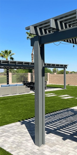 Freestanding pergola with lighting in a yard with pavers