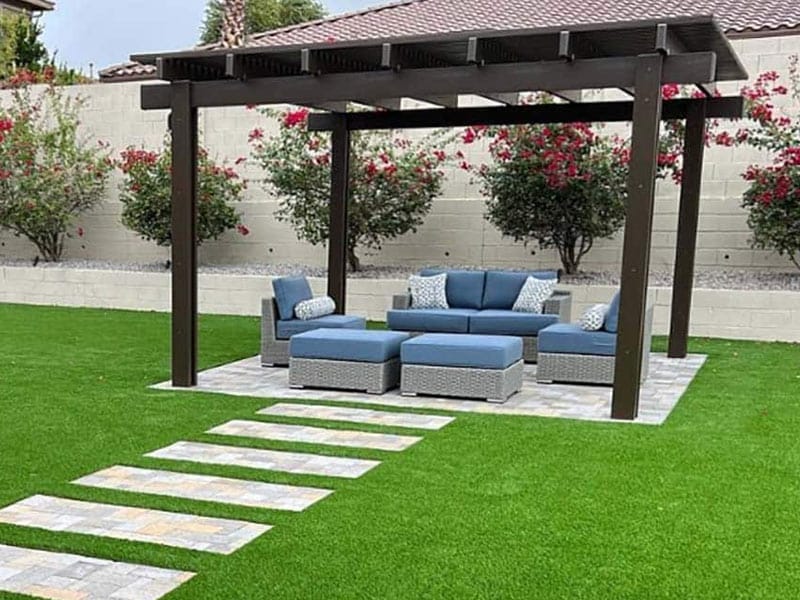 Outdoor sitting area with pergola surrounded by fake grass