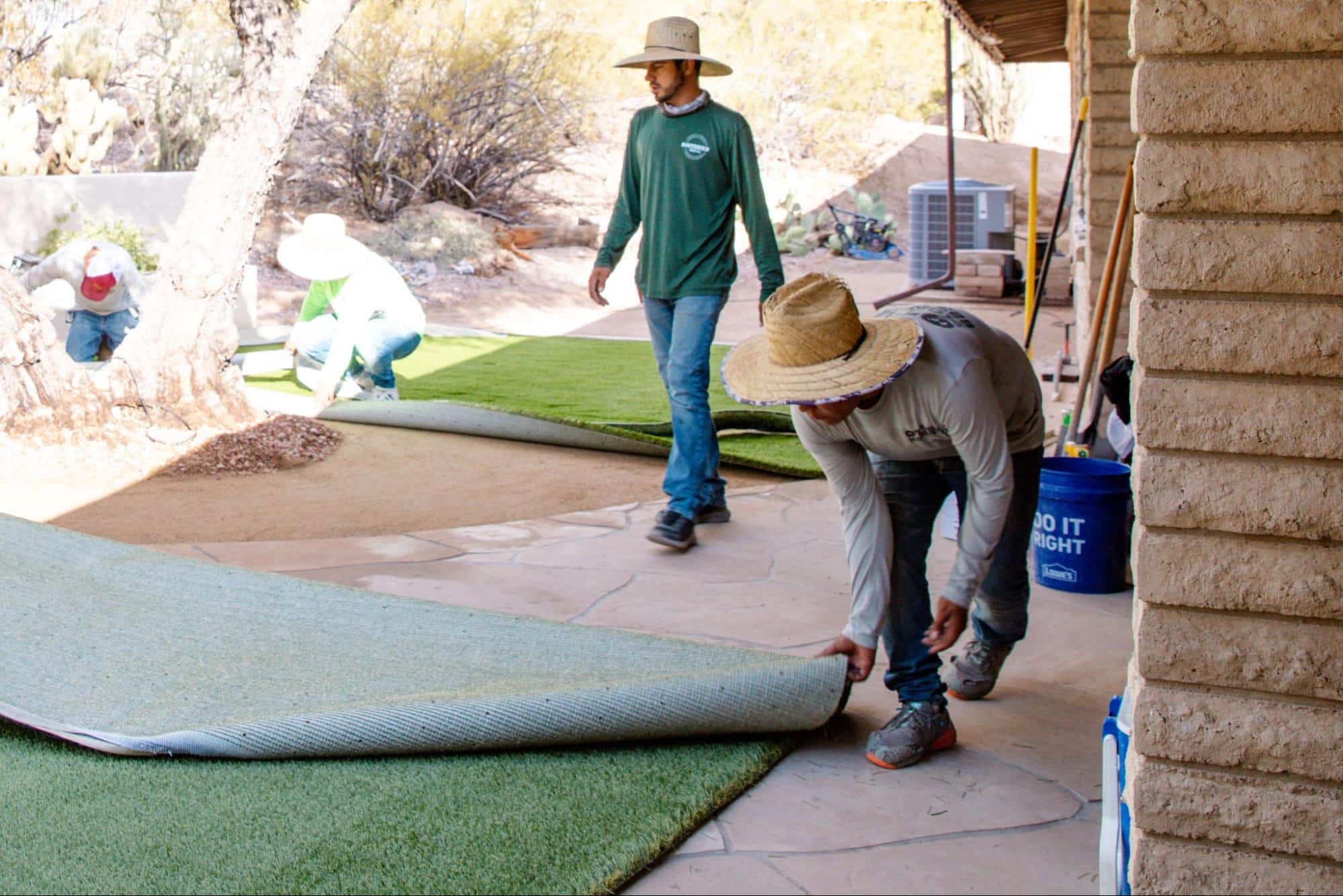 Turf Monsters team about to lay artificial turf in a backyard