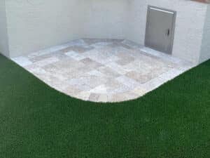 Green fake grass cut perfectly around backyard BBQ